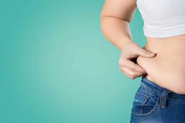 Image of woman pinching her love handles to show weight gain Harwich